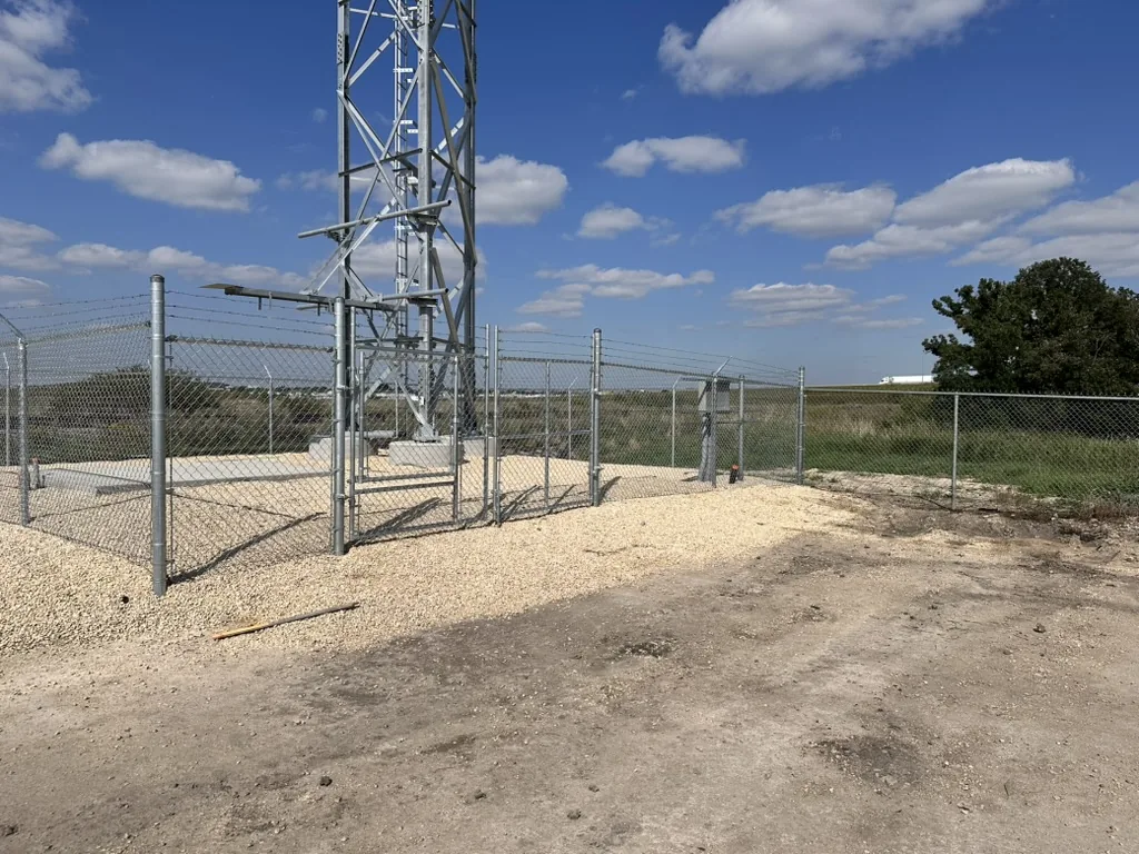 Barbed wire perimeter fence on open land