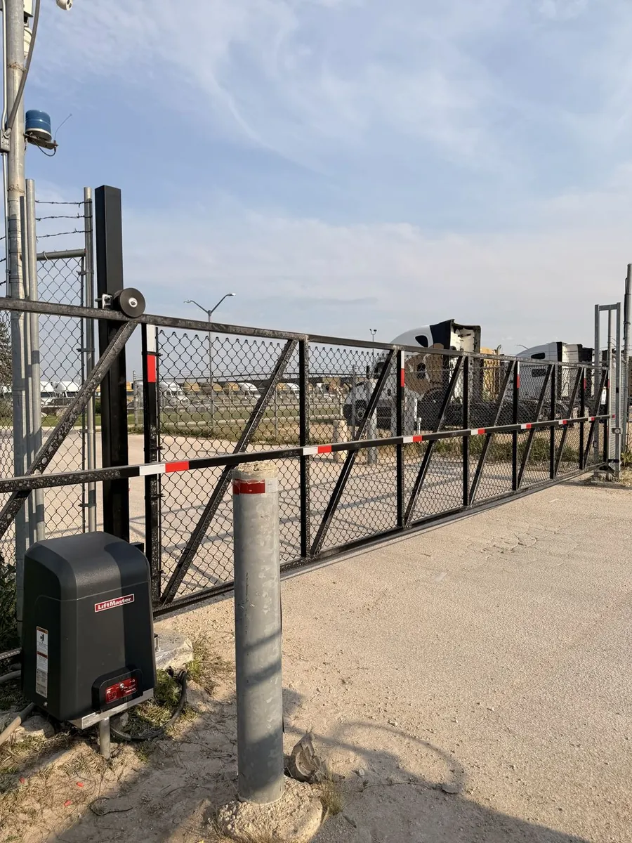 Automated chain link cantilever slide gate with a LiftMaster gate operator at a commercial yard