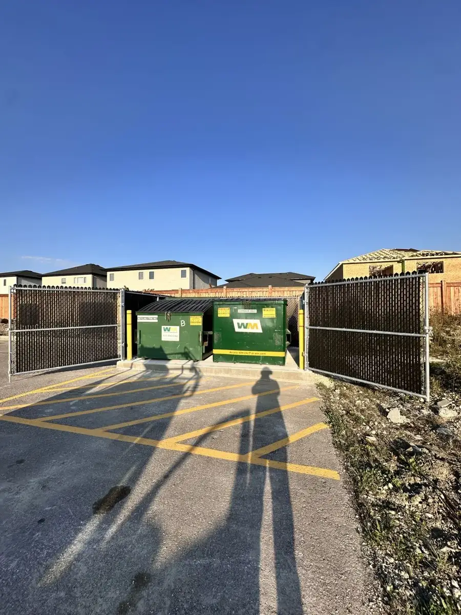 Garbage enclosure with chain link gates and privacy inserts