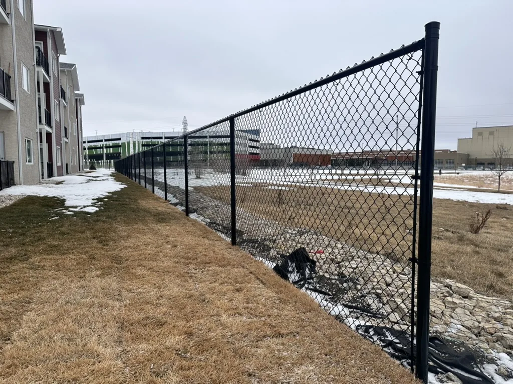 Black commercial chain link fence along an apartment property