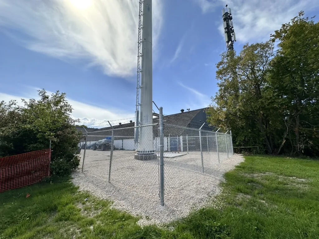 Galvanized chain link compound with barbed wire around a cell tower