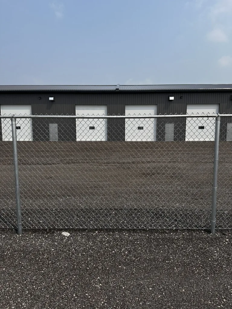 Galvanized commercial chain link fence in front of a row of storage units