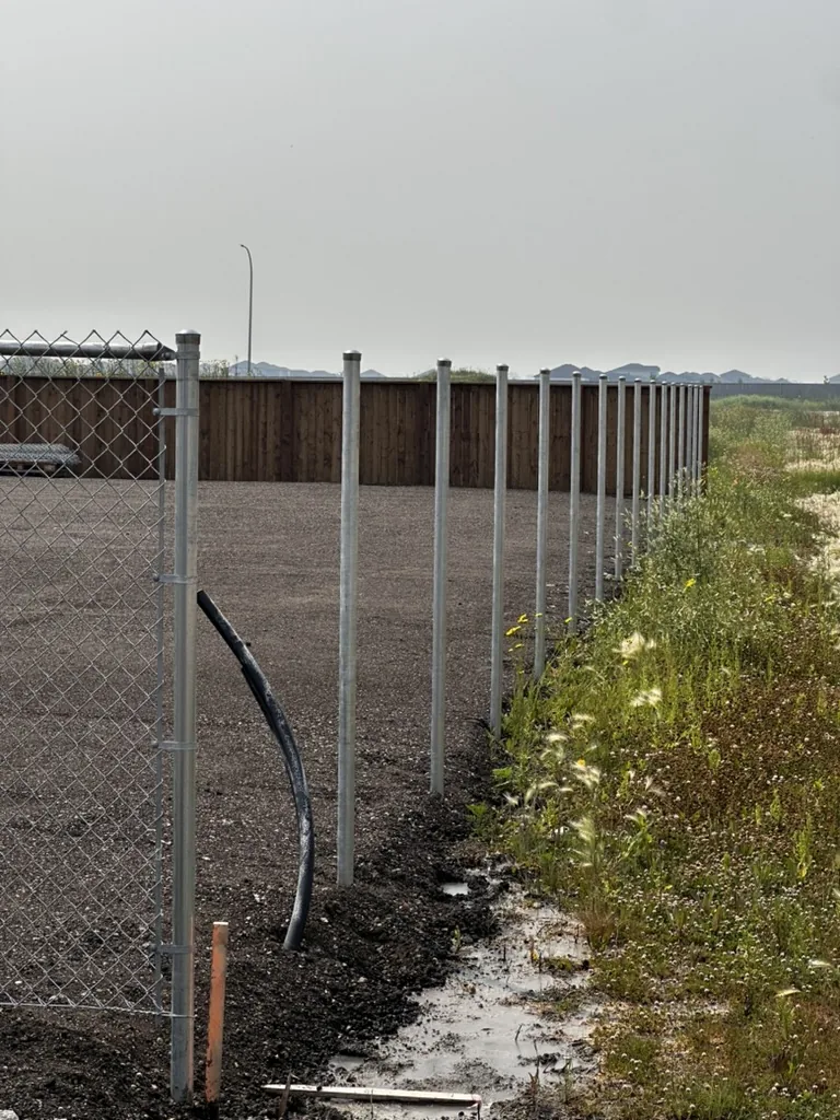 S Tier Security technician checking a commercial gate post installation