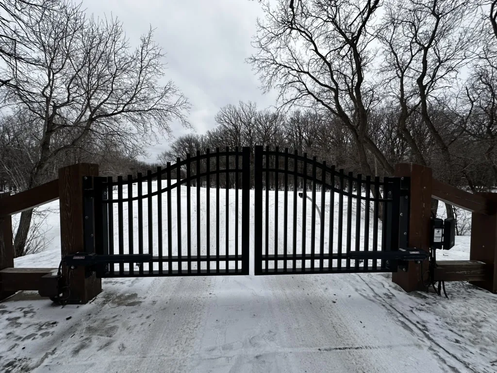 Ornamental automatic swing driveway gate in a Winnipeg winter
