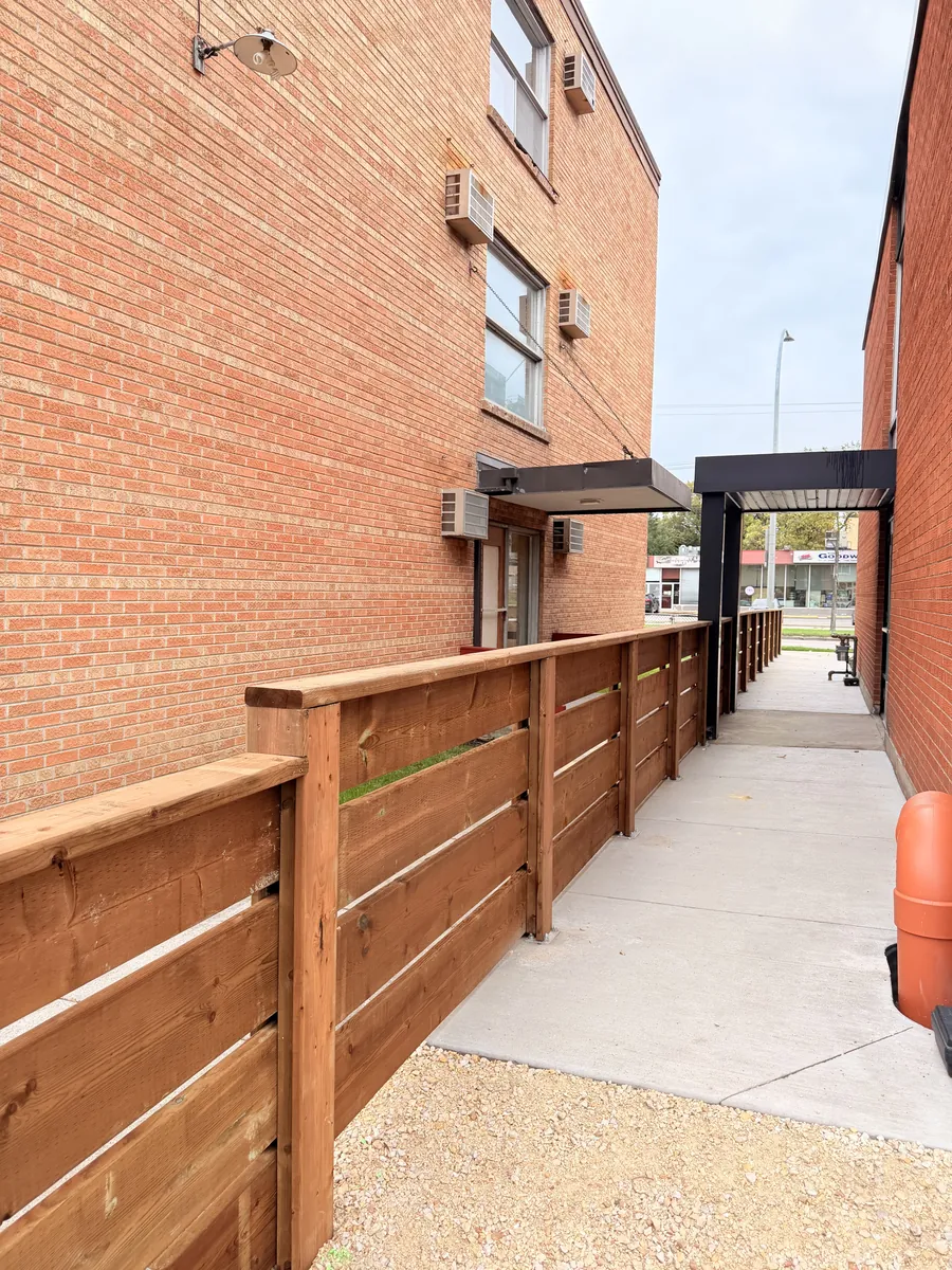 Horizontal wood screen fence along an apartment walkway