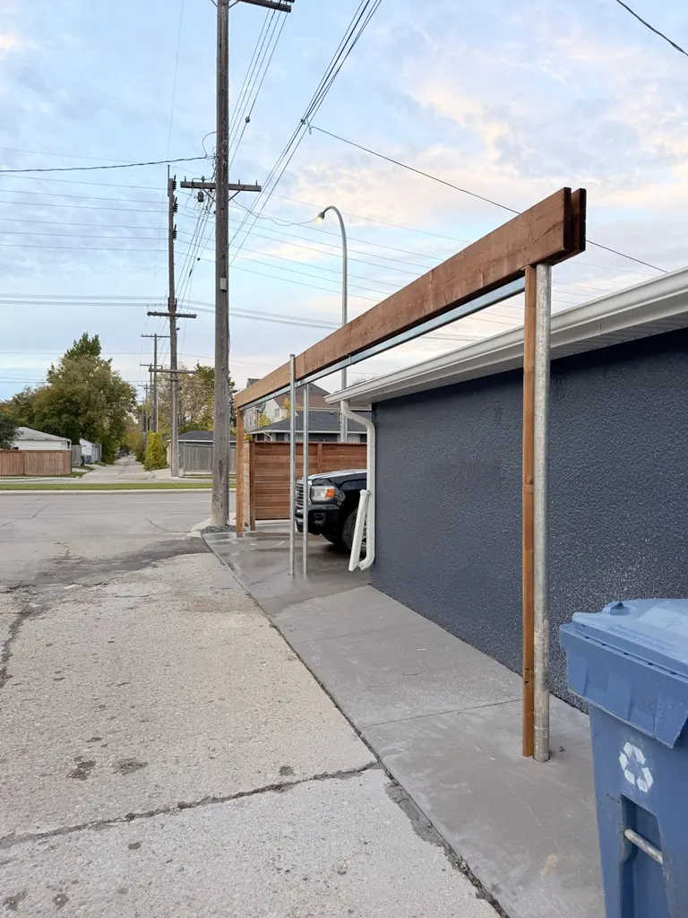 Driven steel posts carrying a wood beam for an overhead slide gate, before the gate is hung